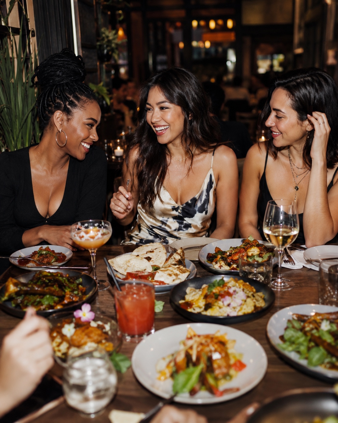 Three women laughing over dinner